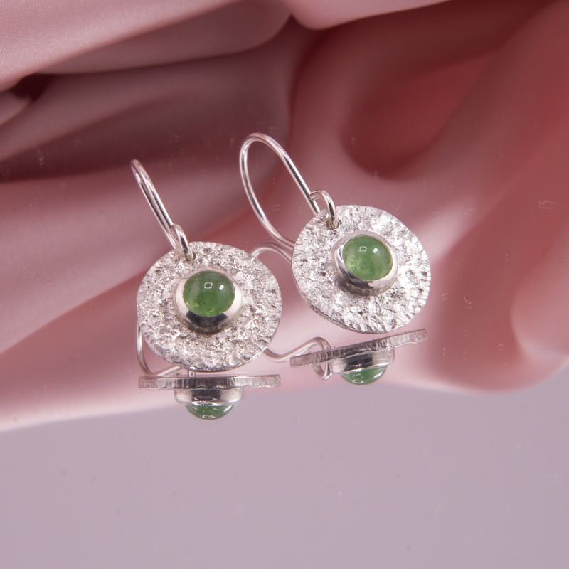 Nahaufnahme der Tsavorit Ohrhänger mit grünen Cabochons und Strukturoberfläche.